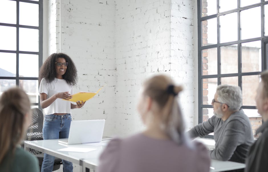 A diverse team engaged in a vibrant office meeting led by a woman presenting ideas